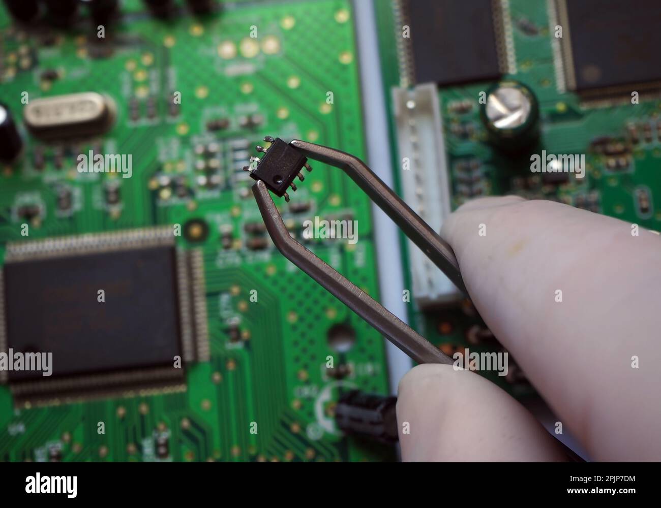 Puce de montage en surface retirée de la carte. Insertion de Microchip sur une carte électronique. Banque D'Images