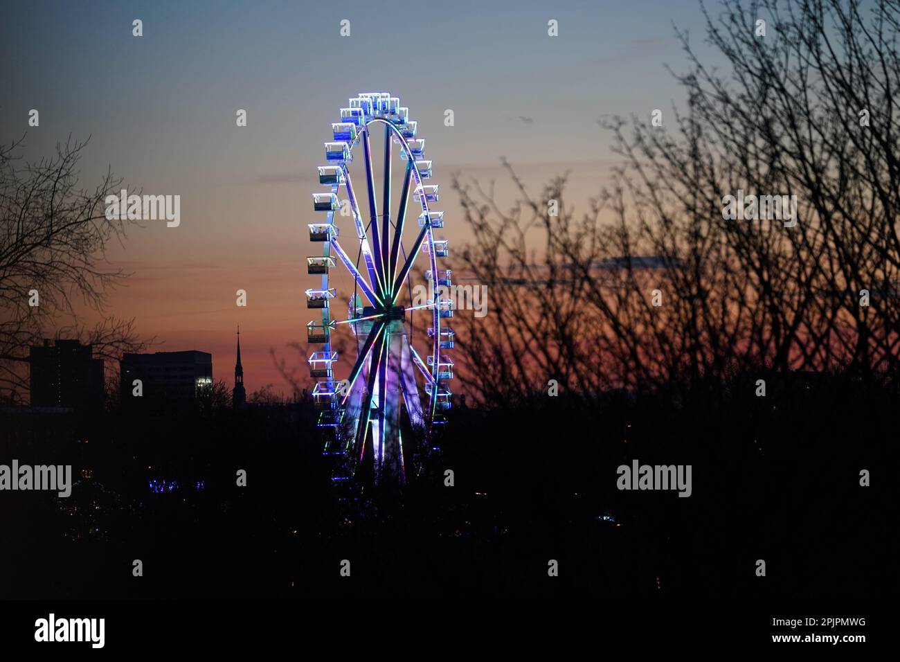 Hambourg, Allemagne. 03rd avril 2023. La grande roue du Hamburg Spring Dome, sur le Heiligengeistfeld, est illuminée en couleurs. Credit: Marcus Brandt/dpa/Alay Live News Banque D'Images