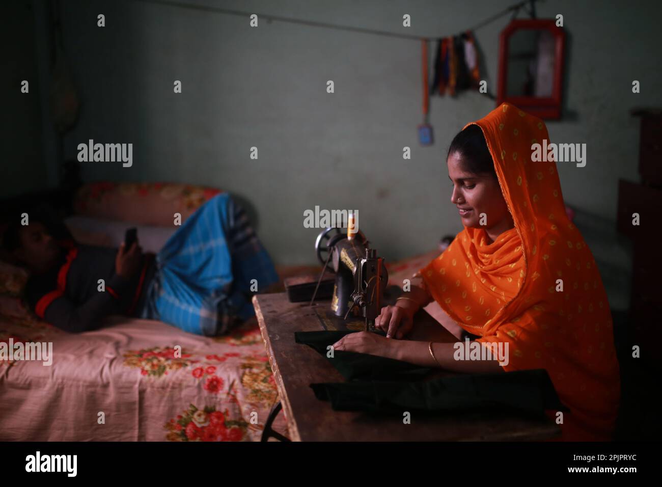 Un ouvrier du vêtement travaille chez lui au Bangladesh. Banque D'Images