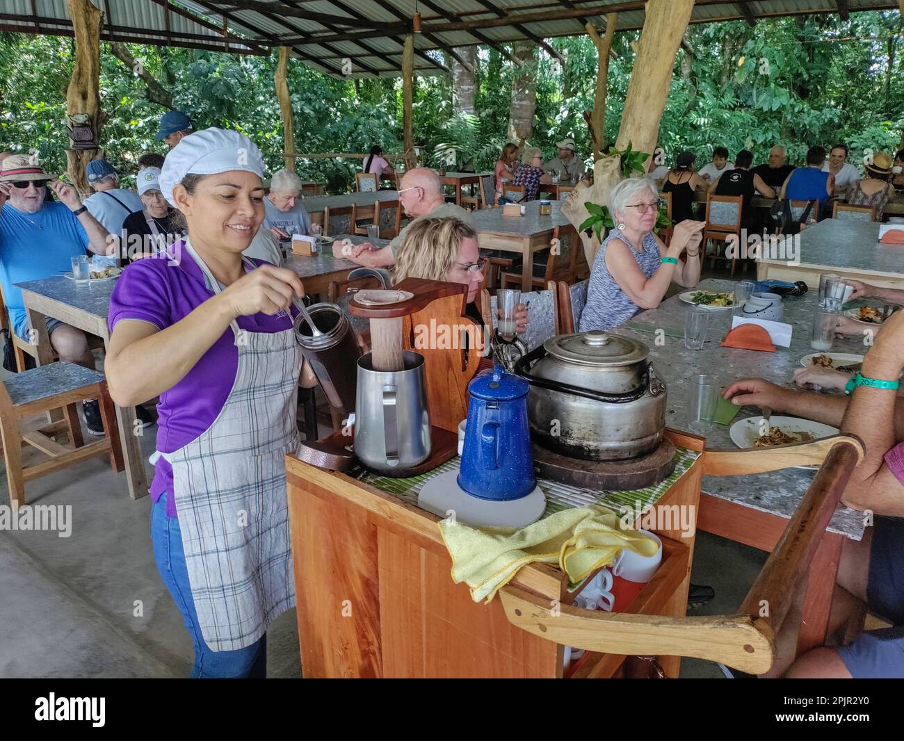 La Fortuna, Costa Rica - Un ouvrier prépare du café pour le déjeuner à Finca Educativa Don Juan (Don Juan Educativa Farm). Les clients aident à préparer le repas, qui Banque D'Images