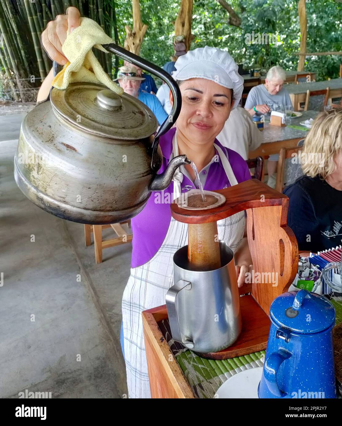 La Fortuna, Costa Rica - Un ouvrier prépare du café pour le déjeuner à Finca Educativa Don Juan (Don Juan Educativa Farm). Les clients aident à préparer le repas, qui Banque D'Images