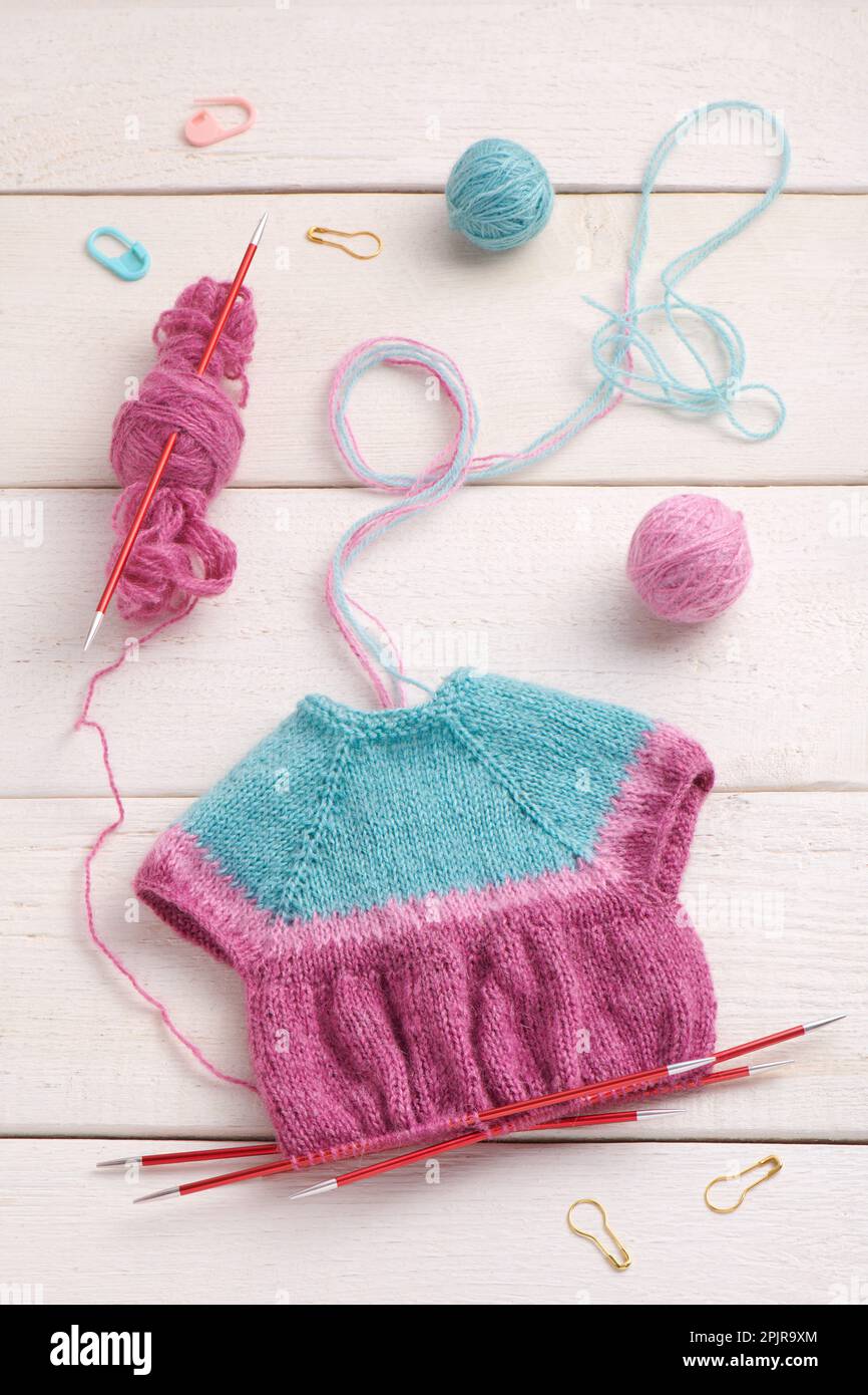 Le processus de tricoter une robe de poupée sur des aiguilles de tricotage, tricotage des accessoires Banque D'Images