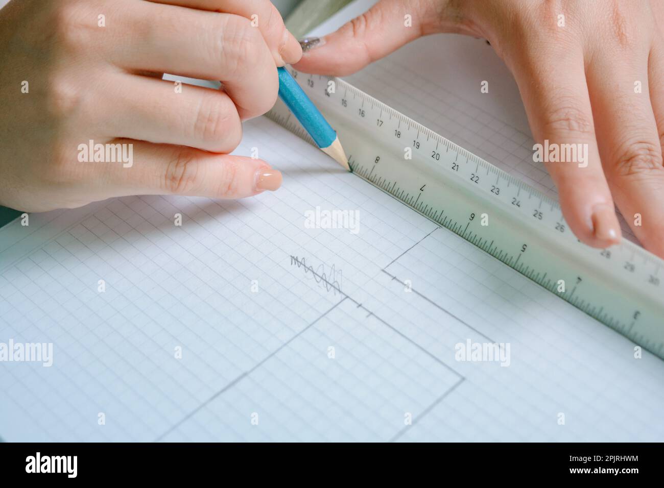 gros plan des mains blanches des femmes en ligne sur une feuille de grille avec une règle graduée et un crayon graphite, design intérieur et travail d'architecture. station santé copy Banque D'Images