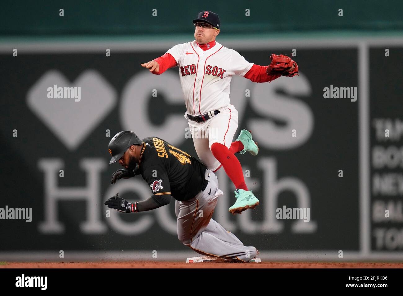 Boston Red Sox shortstop Enrique Hernandez, top, leaps over Pittsburgh Pirates' Carlos Santana (41) on a force-out during the third inning of a baseball game at Fenway Park, Monday, April 3, 2023, in Boston. (AP Photo/Charles Krupa) Banque D'Images