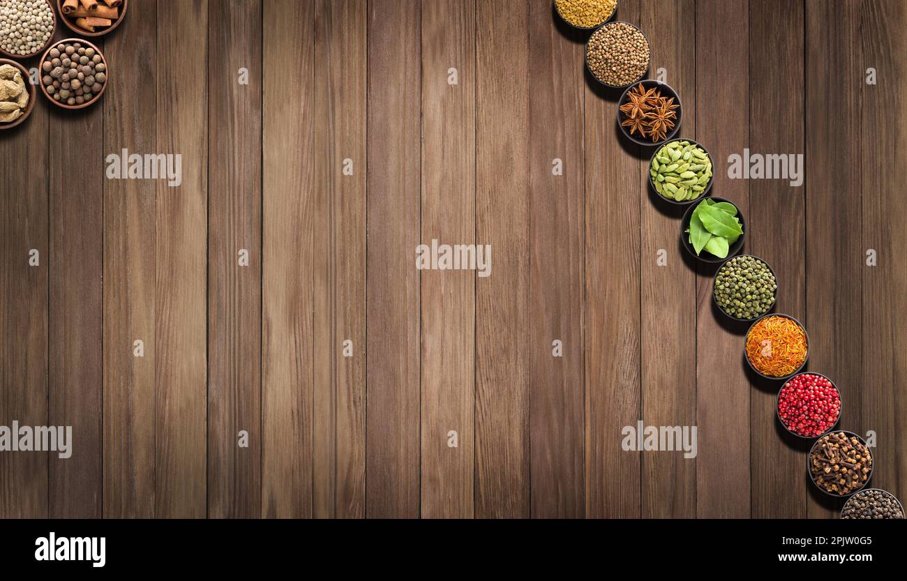 placez les assaisonnements colorés sur une table en bois. Fond d'épices et d'herbes pour les étiquettes alimentaires Banque D'Images