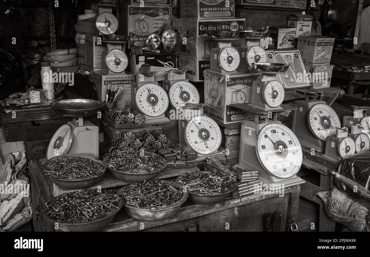 Balances, clous, charnières et autres articles de quincaillerie et quincaillerie à vendre sur une cale au marché central de Pleiku, Vietnam. Banque D'Images