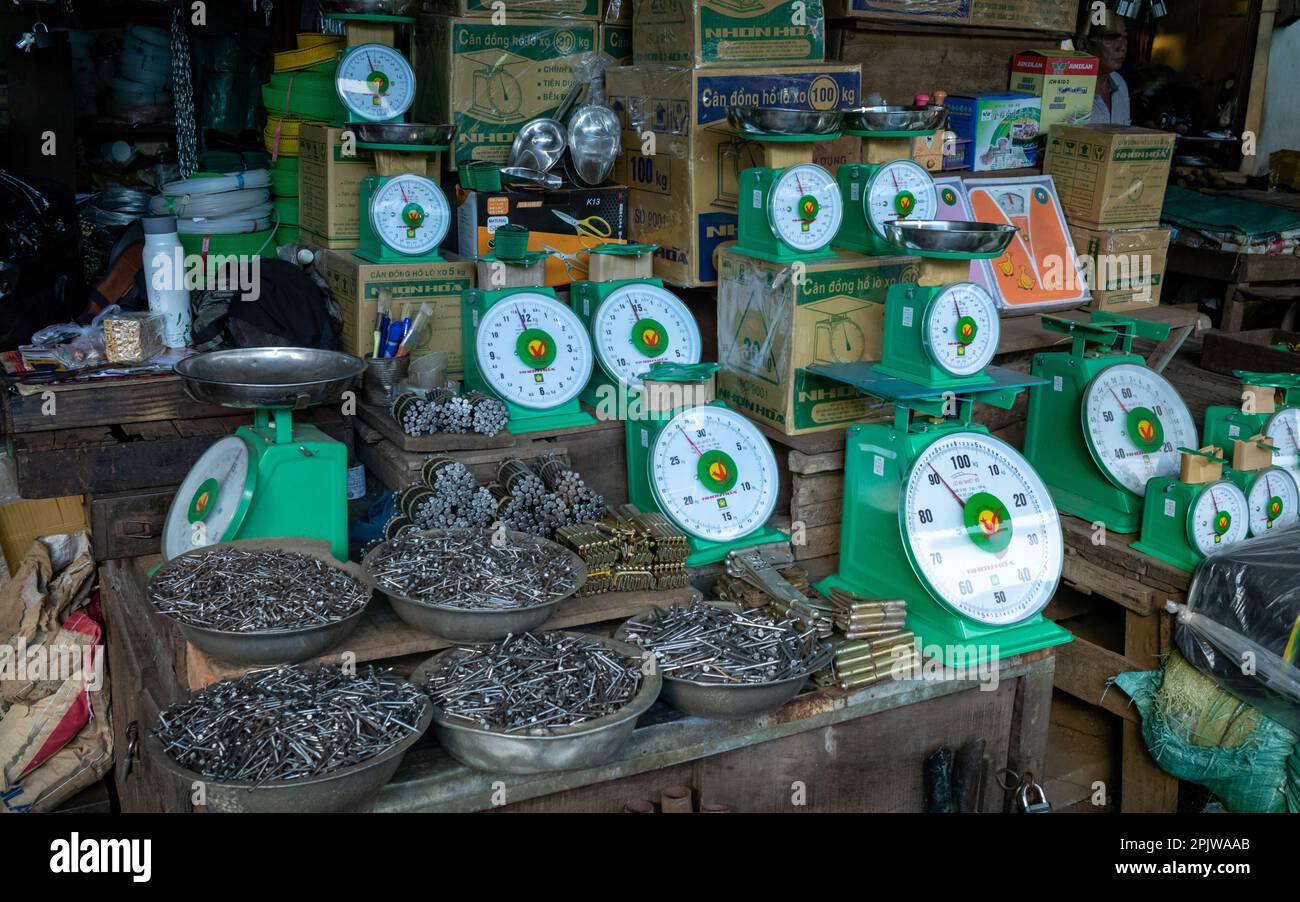Balances, clous, charnières et autres articles de quincaillerie et quincaillerie à vendre sur une cale au marché central de Pleiku, Vietnam. Banque D'Images