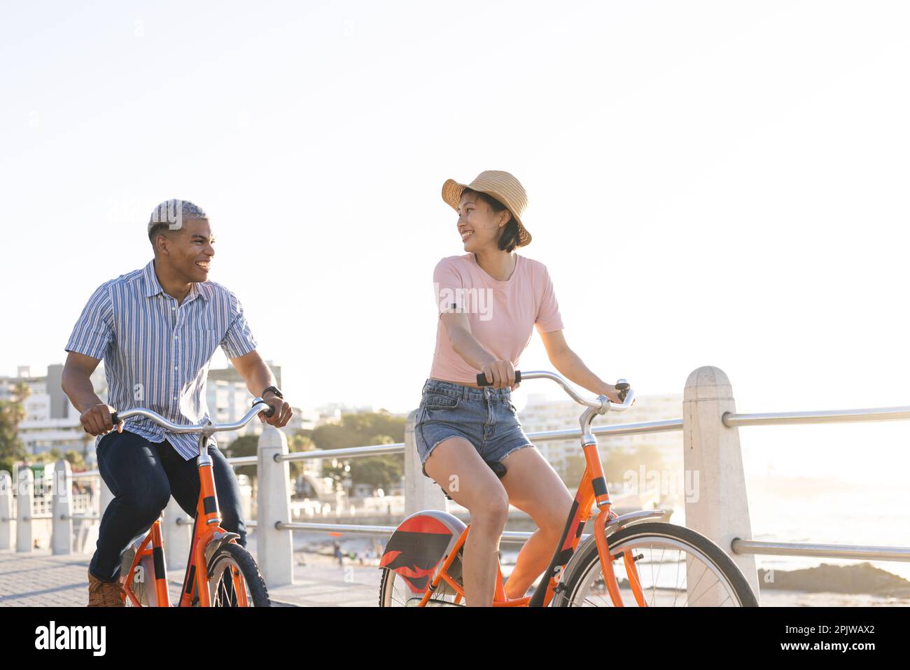 Heureux couple divers à vélo le long de la promenade au bord de la mer Banque D'Images