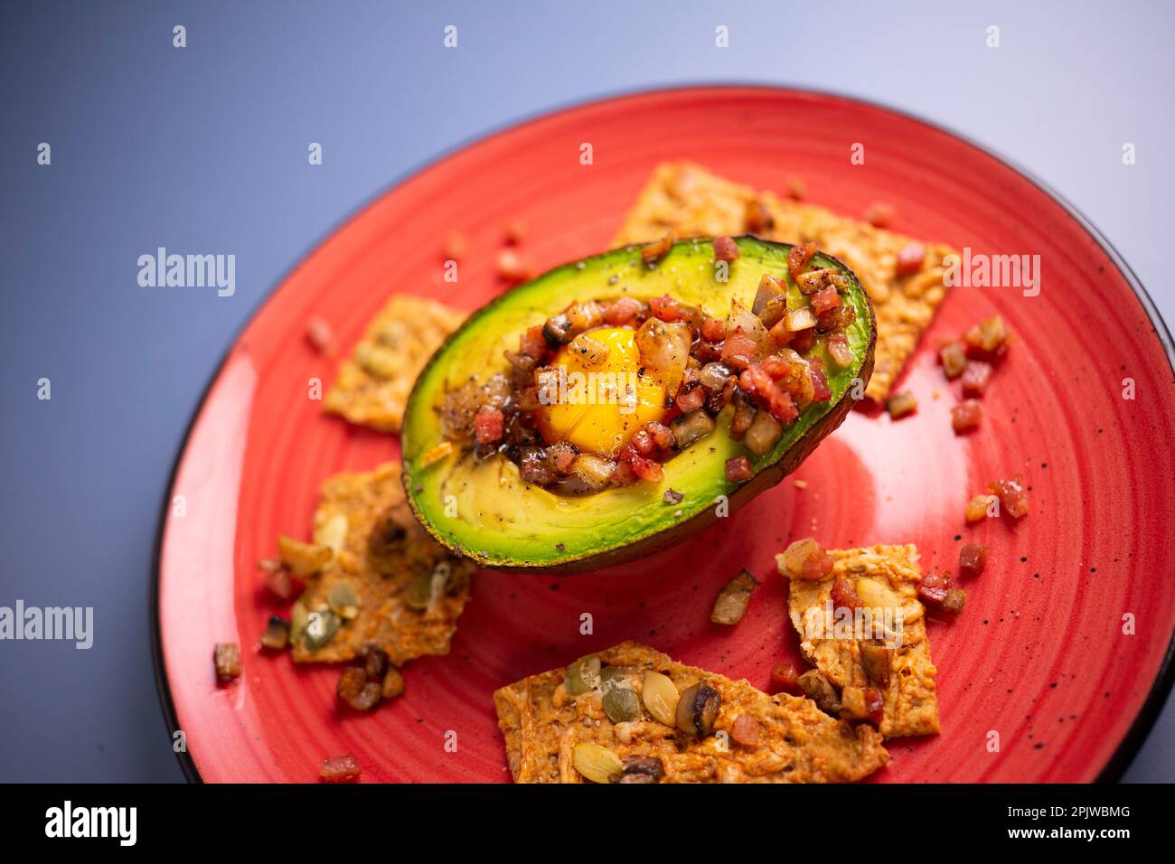 Recette de petit déjeuner avec avocat farci d'oeuf et de jambon. Banque D'Images