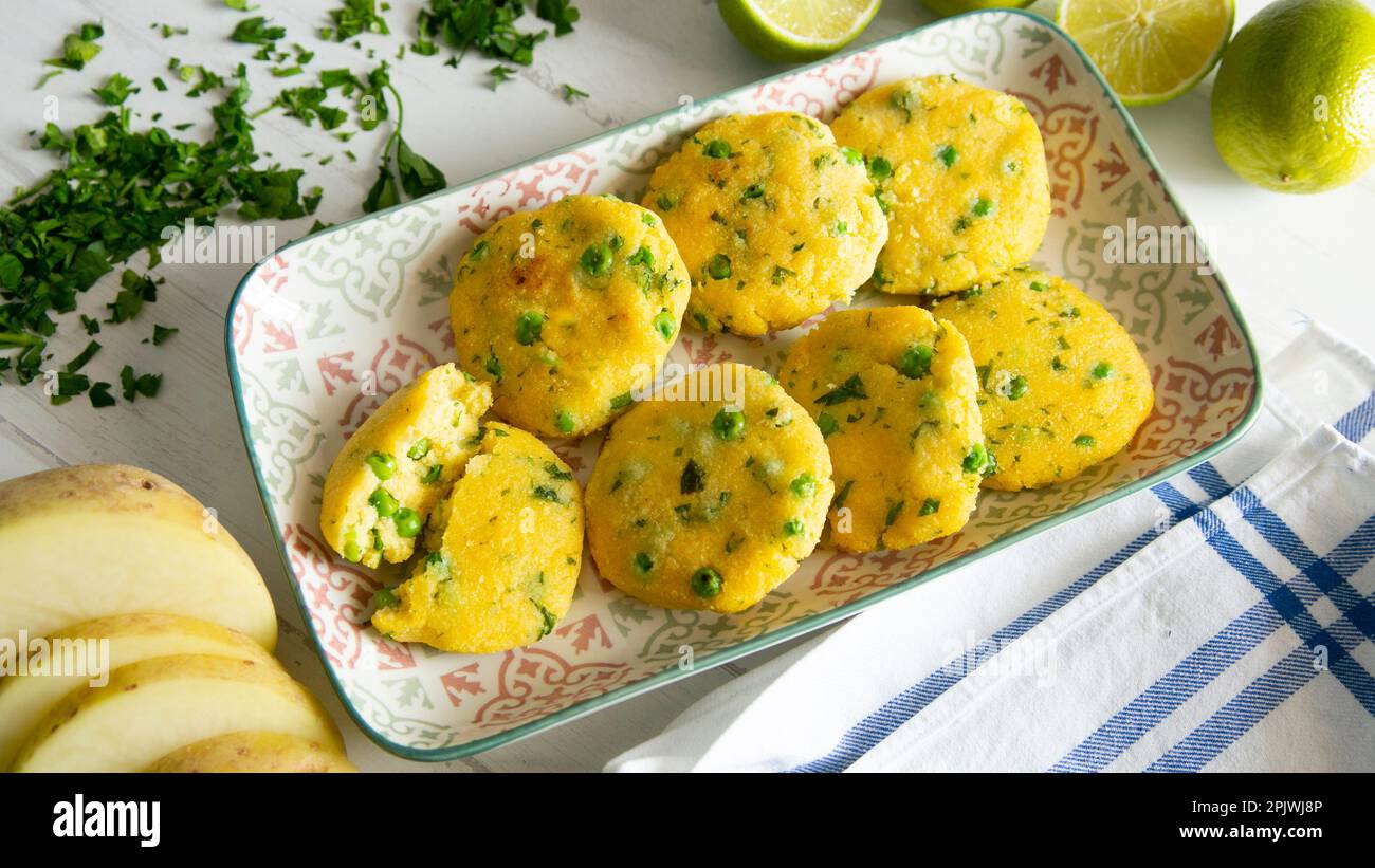 Gâteaux de polenta salés frits avec petits pois. Banque D'Images