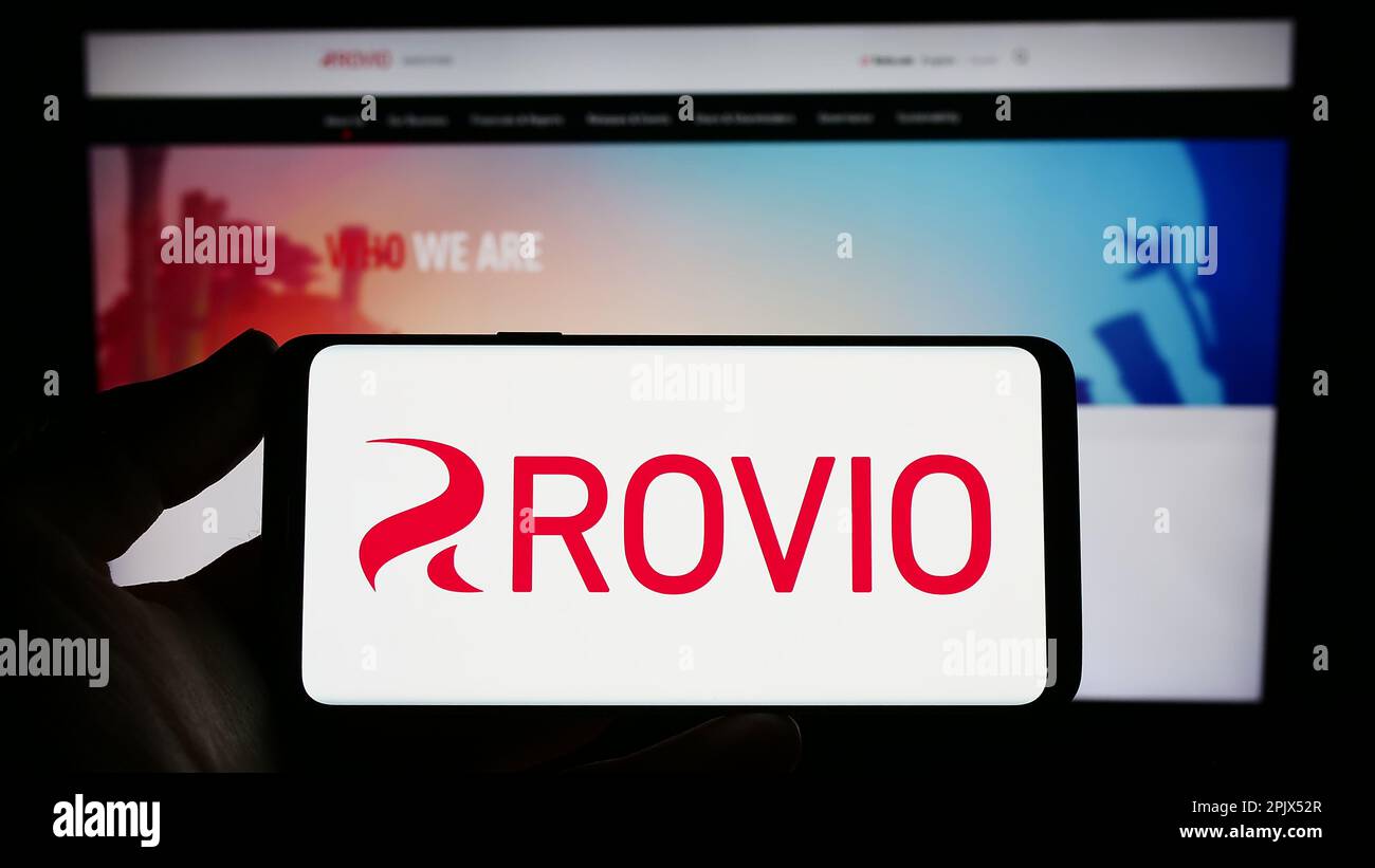 Personne tenant un smartphone avec le logo de la société finlandaise de jeux Rovio Entertainment Oyj sur l'écran devant le site Web. Mise au point sur l'affichage du téléphone. Banque D'Images