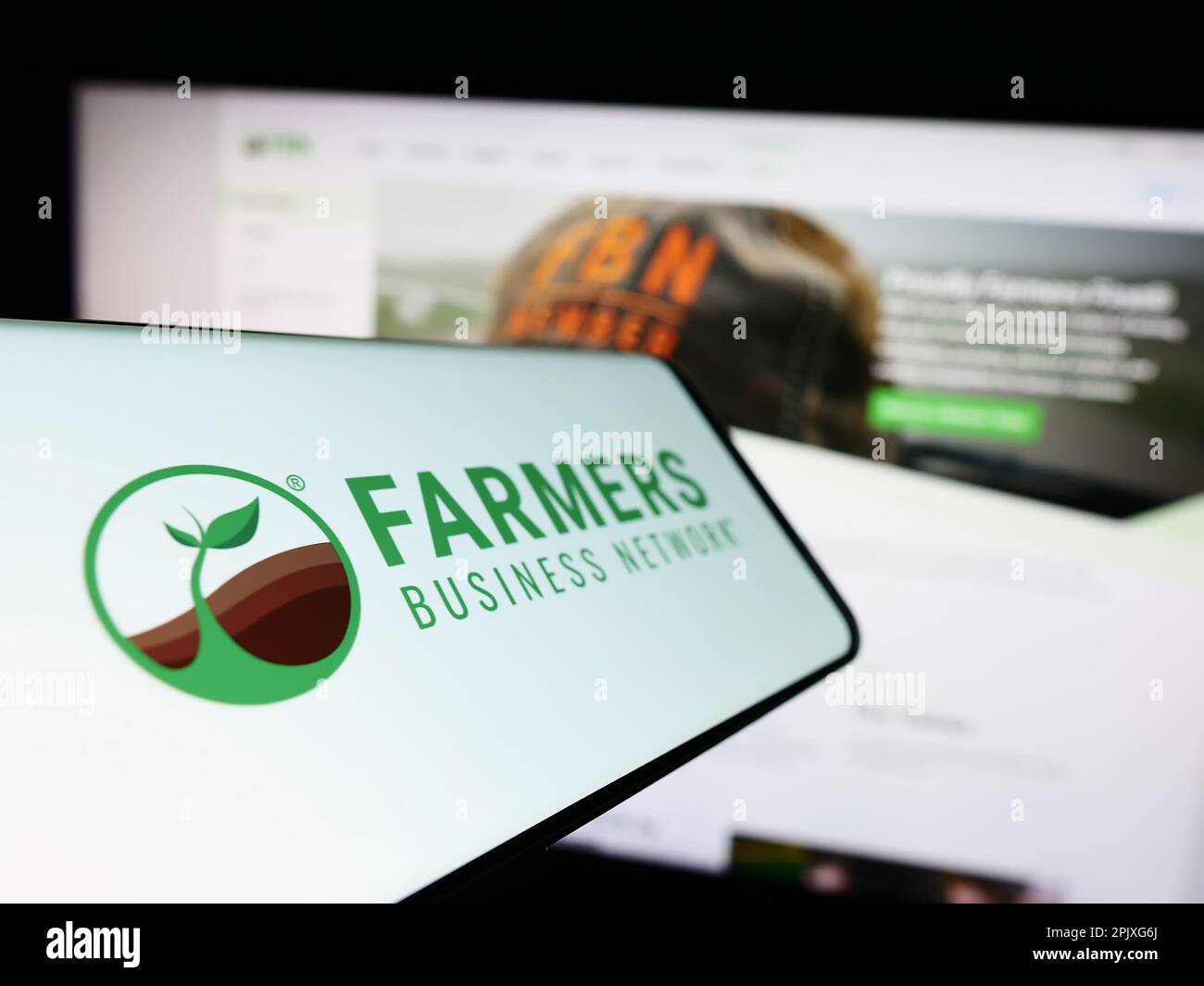 Téléphone portable avec logo de la plate-forme agricole Farmers Business Network (FBN) à l'écran devant le site Web. Mise au point au centre-gauche de l'écran du téléphone. Banque D'Images