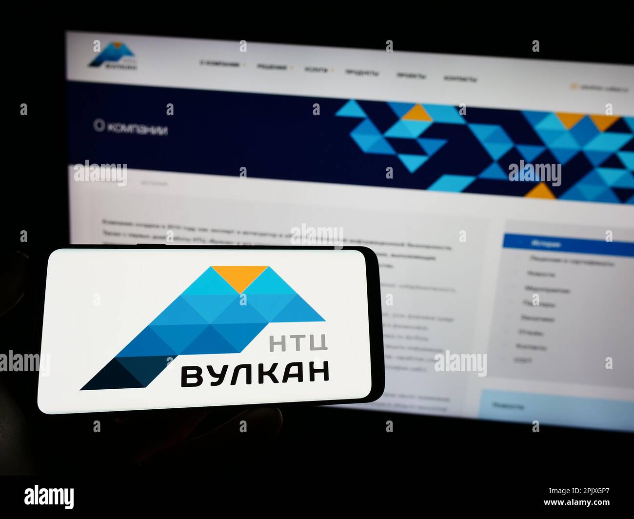 Personne tenant un téléphone portable avec le logo de la société russe de technologie de l'information NTC Vulkan à l'écran en face de la page Web. Mise au point sur l'affichage du téléphone. Banque D'Images
