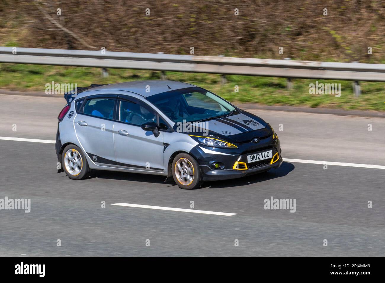 2012 argent modifié FORD FIESTA EDGE 1242cc (1.25I 82) essence manuelle à 5 vitesses ; se déplaçant à grande vitesse sur l'autoroute M6 dans le Grand Manchester, Royaume-Uni Banque D'Images