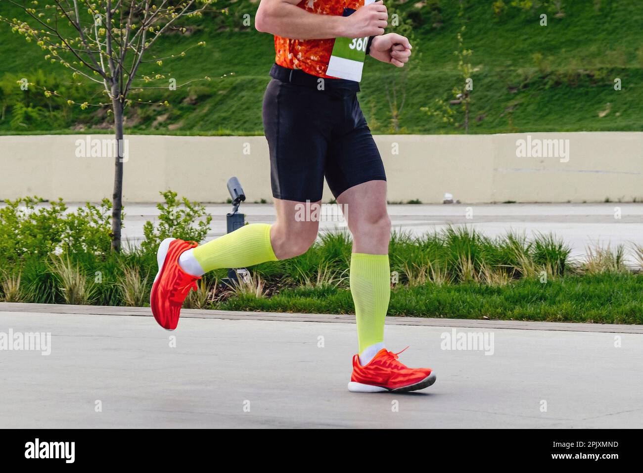 coureur masculin en chaussettes de compression course marathon distance dans le parc de la ville, compétition de sports d'endurance Banque D'Images