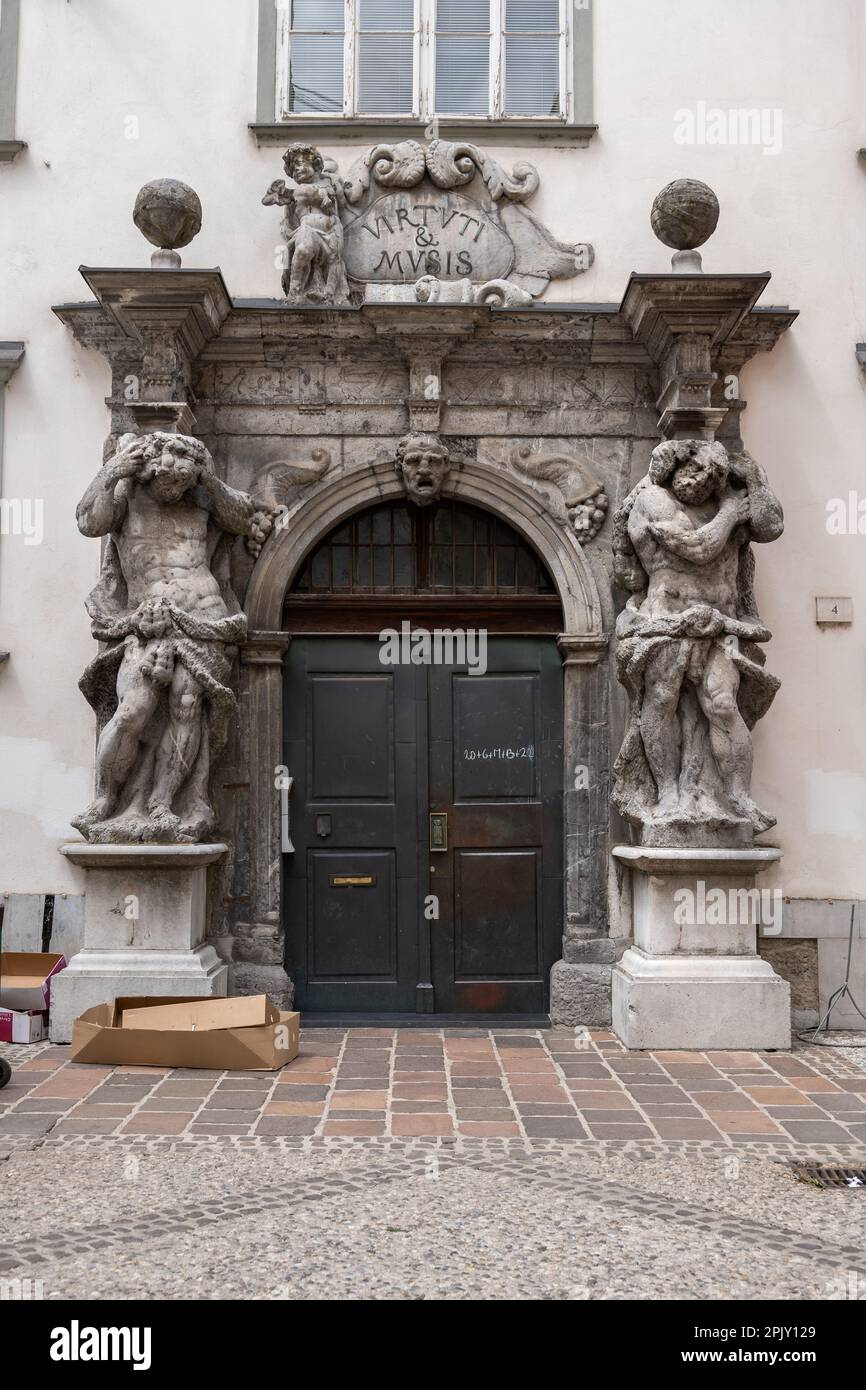 Slovénie, Ljubljana, Portail de Ljubljana Bibliothèque du palais théologique de Ljubljana, entrée avec deux sculptures de l'Atlas flanquant la porte. Travail de portail Banque D'Images