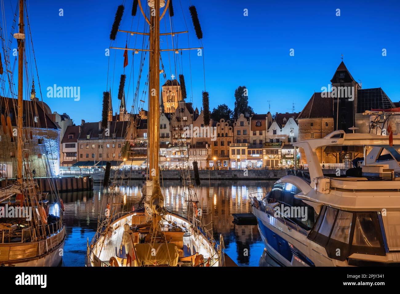 Vue sur la ville de Gdansk au crépuscule en Pologne. Vue sur la vieille ville depuis la marina avec bateaux à voile et yachts. Banque D'Images