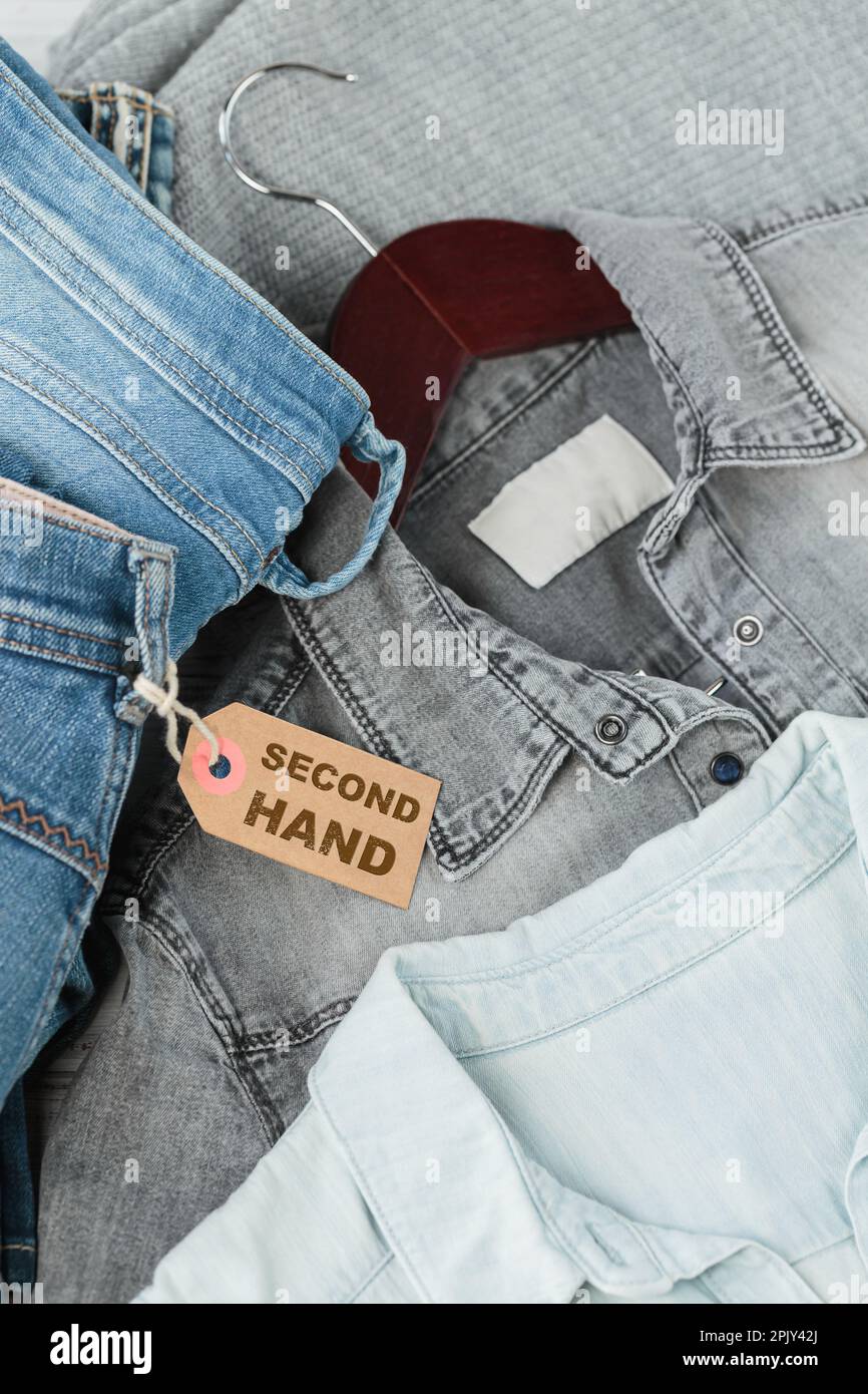 Pile de jeans bleus et étiquette avec inscription d'une seconde main Photo  Stock - Alamy