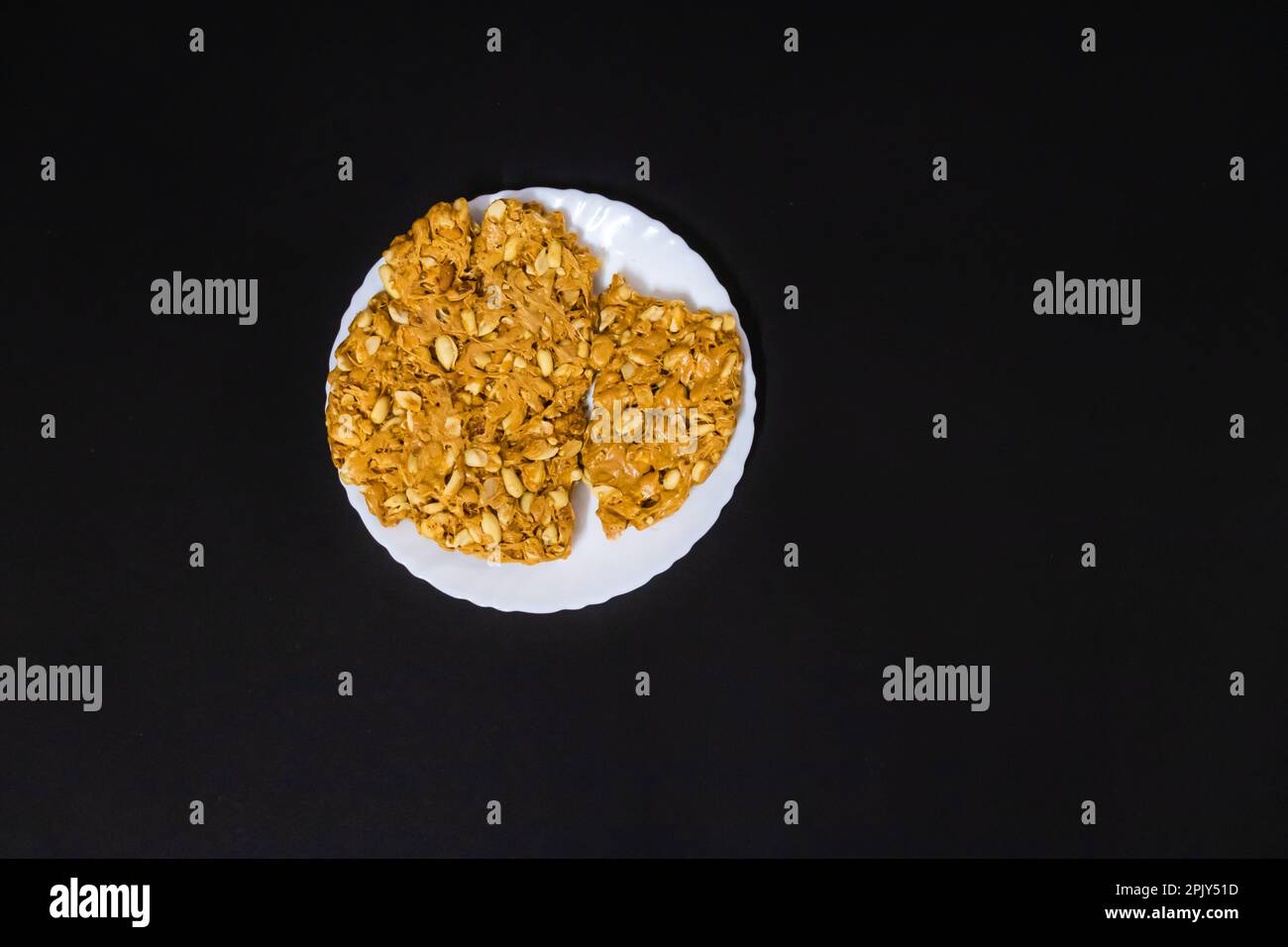 gazak traditionnel indien sucré dans une assiette blanche avec fond noir Banque D'Images