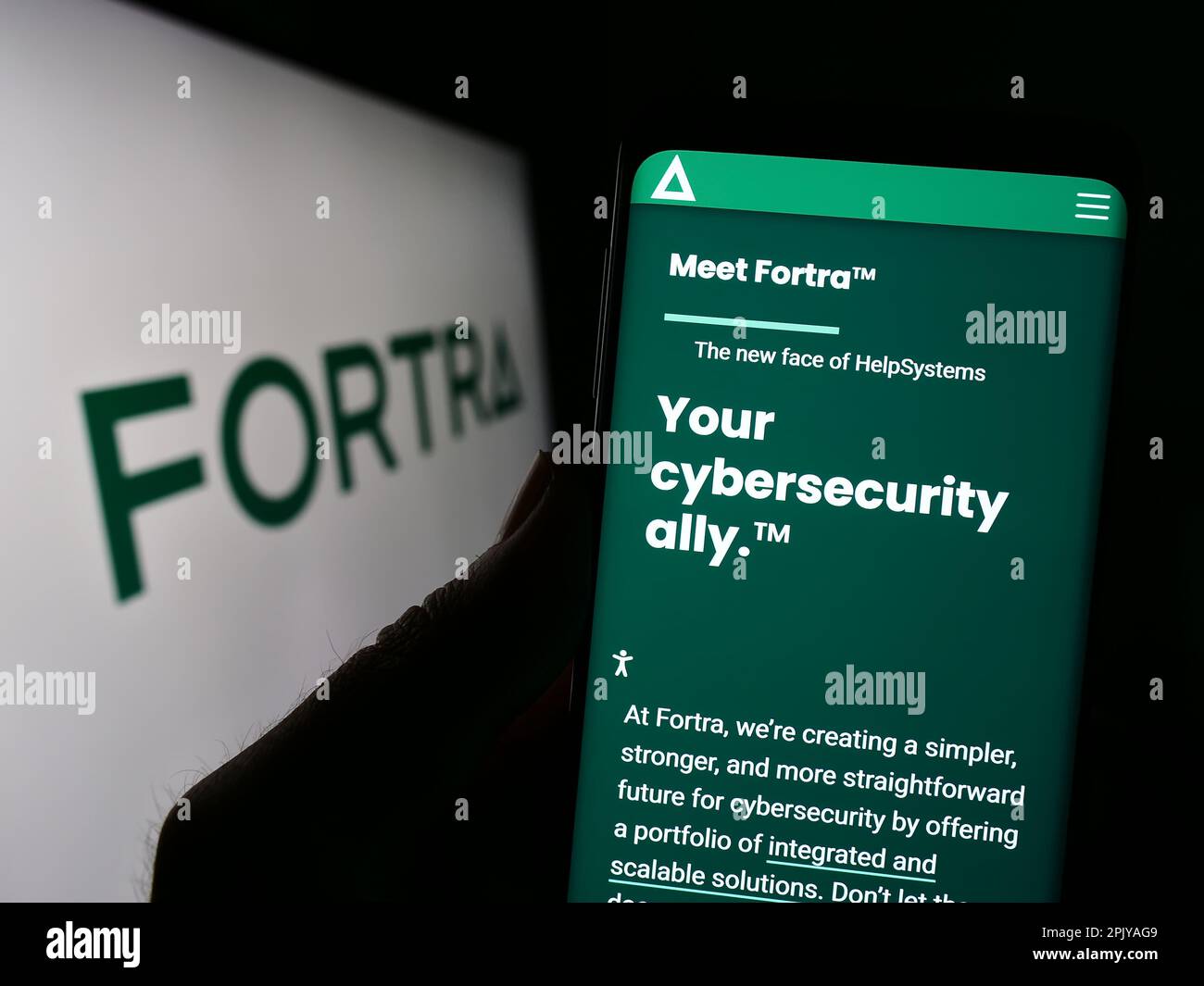 Personne tenant un téléphone portable avec le site Web de la société américaine de cybersécurité Fortra LLC à l'écran devant le logo. Concentrez-vous sur le centre de l'écran du téléphone. Banque D'Images