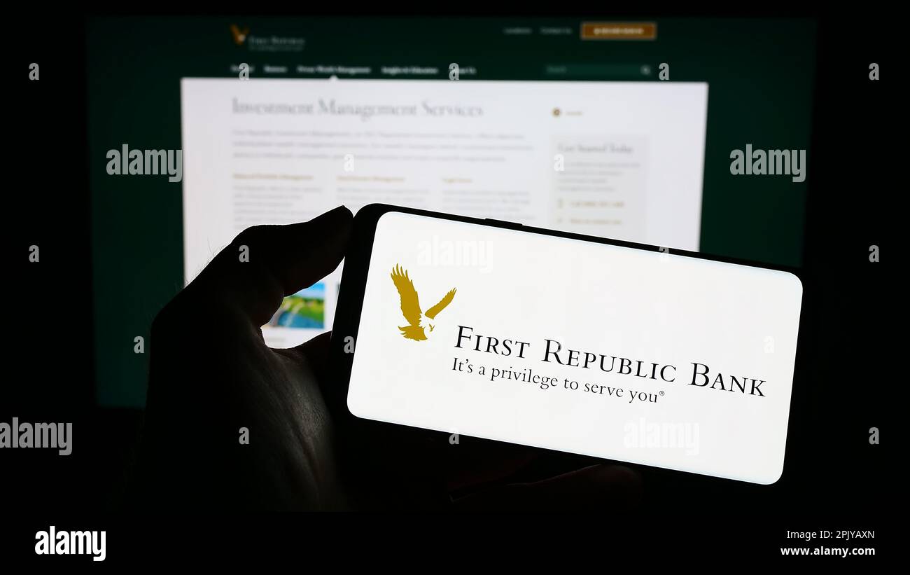 Personne tenant un téléphone portable avec le logo de la société bancaire commerciale américaine First Republic Bank à l'écran en face de la page Web. Mise au point sur l'affichage du téléphone. Banque D'Images