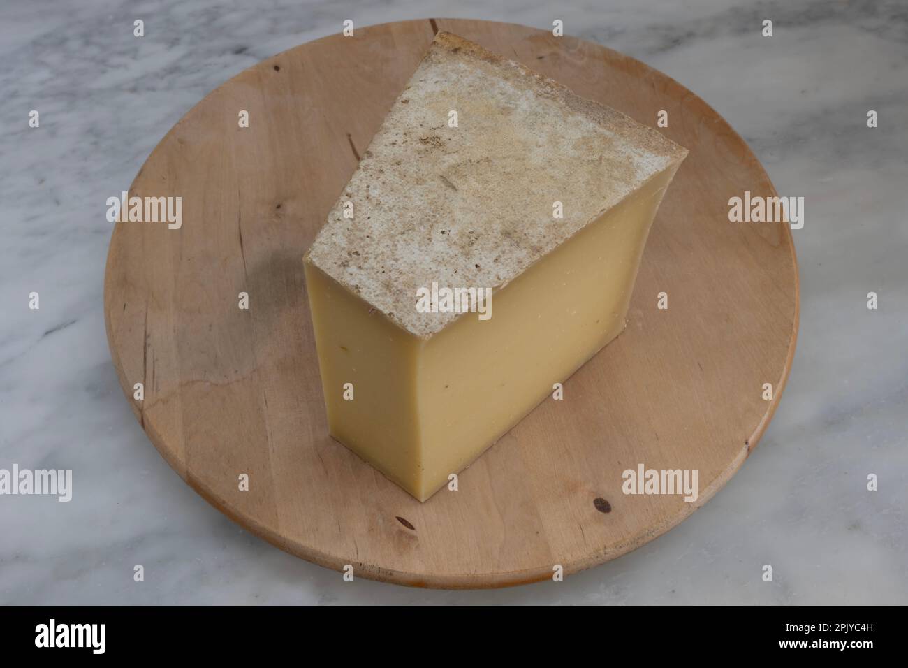 STILL Life culinaire français. Morceau de fromage Beaufort Chalet d'Alpage placé sur une poêle en bois Banque D'Images