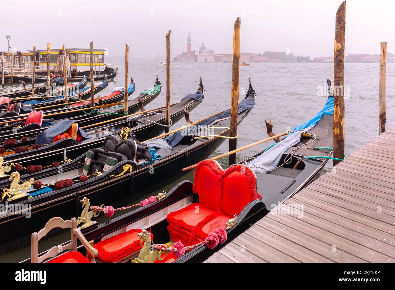 Gondoles amarrées par la place Saint-Marc avec l'église de San Giorgio Maggiore en arrière-plan le matin brumeux, Venise, Italie Banque D'Images