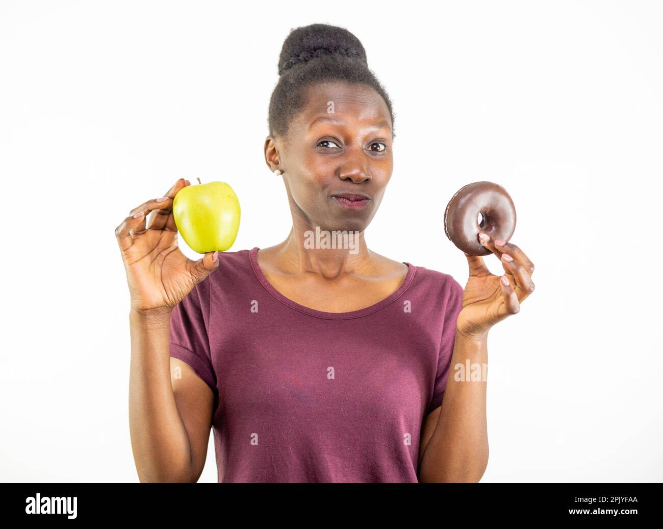 Jeune femme qui choisit entre la nourriture saine et la malbouffe isolée sur fond blanc Banque D'Images