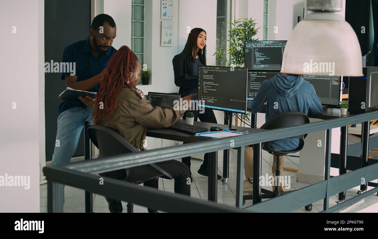 Développeur junior travaillant sur une fenêtre de terminal pour coder un script système, utilisant plusieurs moniteurs avec une base de données de code source. Algorithme d'écriture par programme avec langage html, cloud computing. Banque D'Images