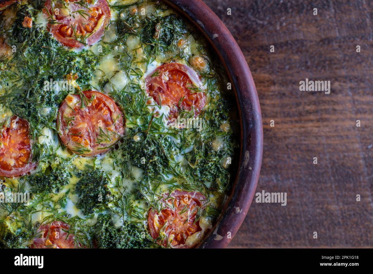 Bol en céramique avec frittata de légumes, simple nourriture végétarienne. Frittata avec oeuf, tomate, poivre, oignon, brocoli vert et fromage sur table en bois, clo Banque D'Images