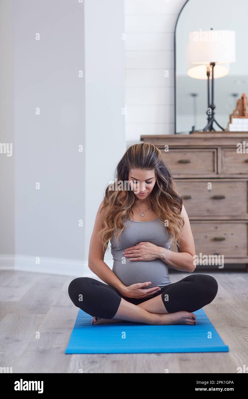 La bonne santé est le plus grand cadeau pour donner à votre bébé. une jeune  femme enceinte pratiquant une routine de yoga à la maison Photo Stock -  Alamy