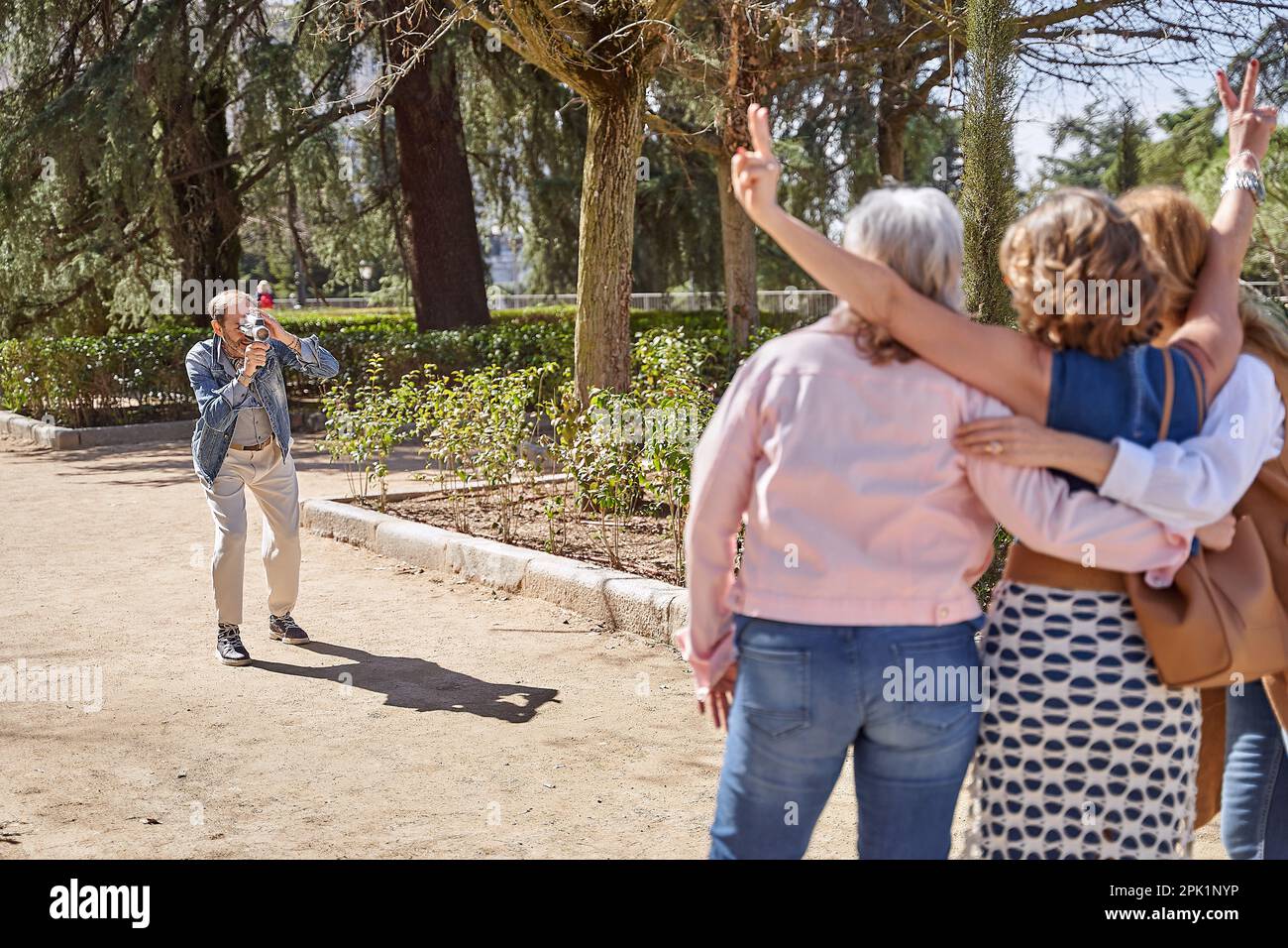 Un homme équipé d'une caméra vidéo vintage capture des souvenirs avec ses trois amis, en préservant leurs moments spéciaux avec une touche d'école ancienne Banque D'Images