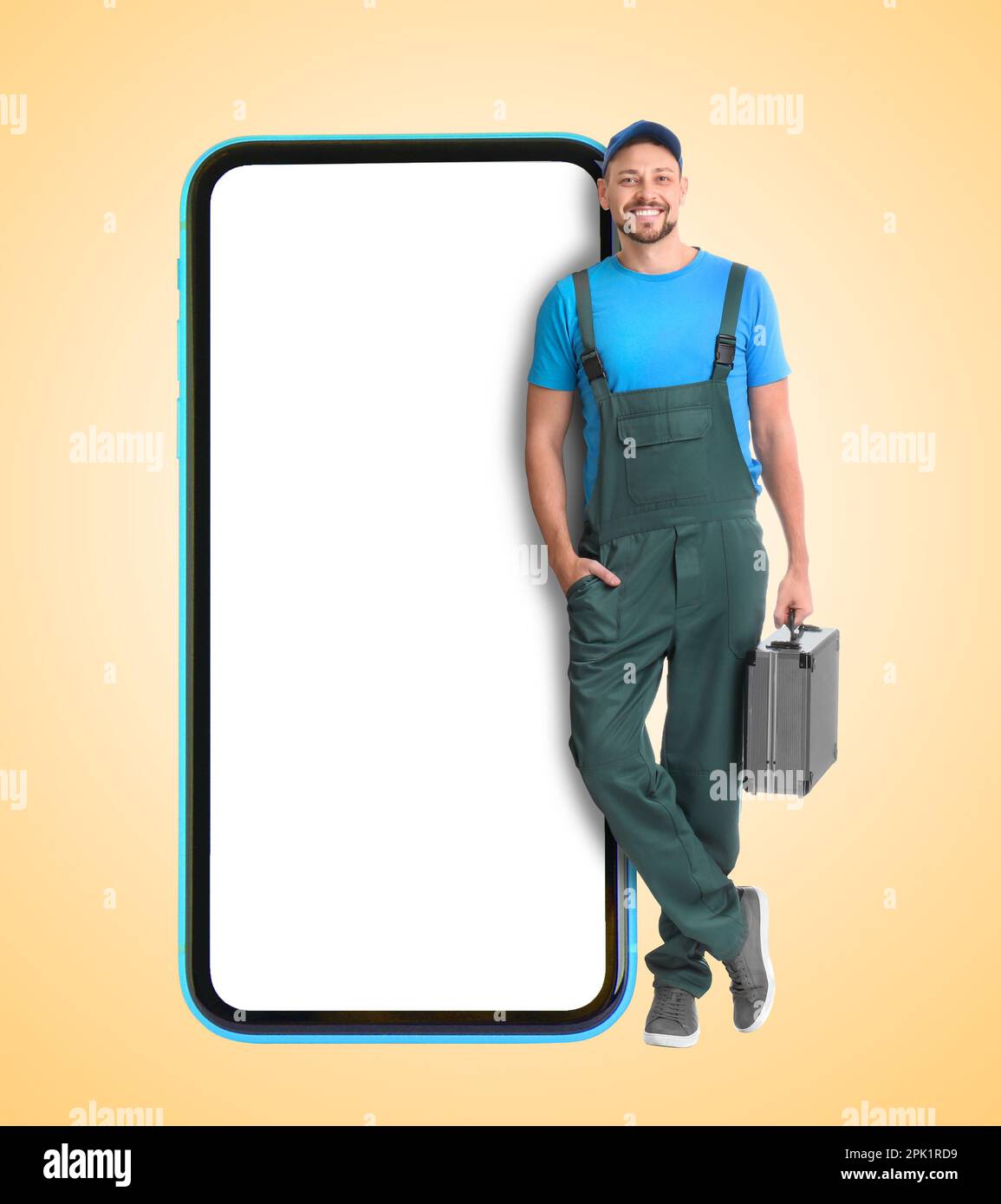 Service de réparation - appelez simplement. Un réparateur professionnel heureux tenant une boîte à outils et un smartphone avec écran vierge sur fond beige, espace pour le design Banque D'Images