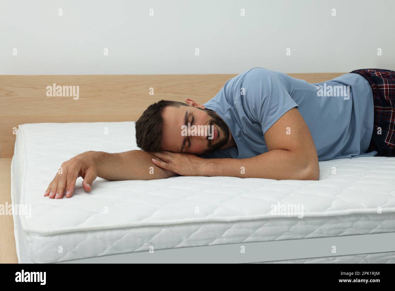 Homme dormant sur un lit avec matelas confortable à la maison Photo Stock -  Alamy