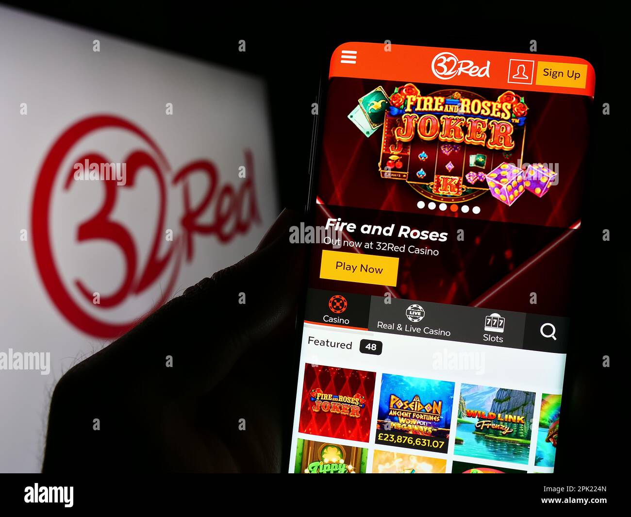 Personne tenant le téléphone portable avec la page web de la compagnie de casino en ligne 32Red limitée à l'écran devant le logo. Concentrez-vous sur le centre de l'écran du téléphone. Banque D'Images