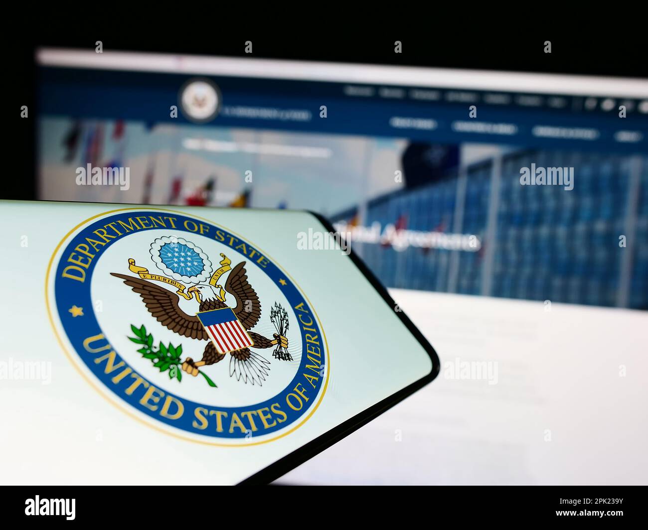 Téléphone cellulaire avec sceau du Département d'État des États-Unis (DOS) sur l'écran devant le site Web. Effectuez la mise au point au centre-droit de l'écran du téléphone. Banque D'Images