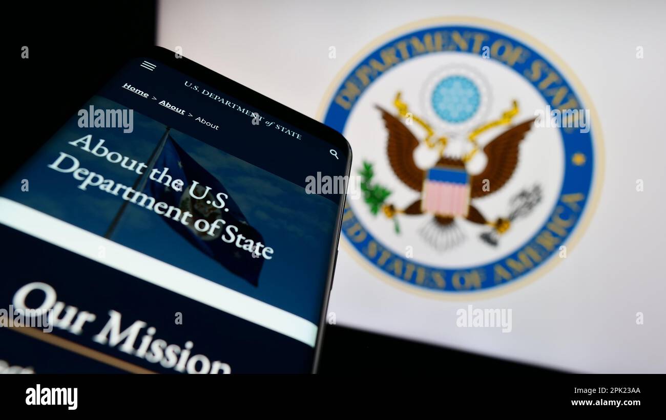 Téléphone mobile avec le site Web du Département d'État des États-Unis (DOS) sur l'écran devant le sceau. Faites la mise au point dans le coin supérieur gauche de l'écran du téléphone. Banque D'Images