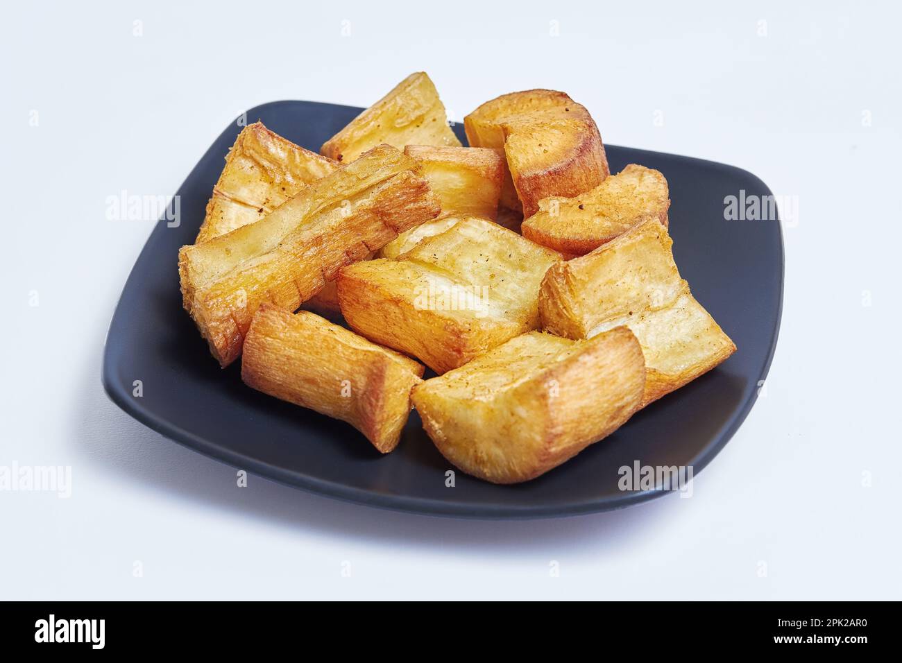 Manioc frit connu sous le nom de 'Singkong goreng', célèbre en-cas simple frit indonésien sur fond blanc isolé Banque D'Images