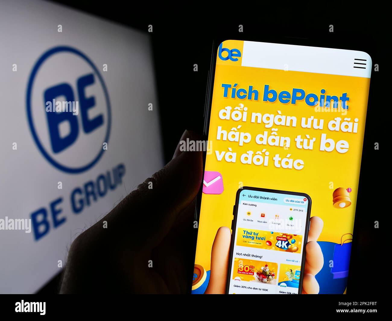 Personne tenant le téléphone portable avec la page web de la société vietnamienne de technologie être le Groupe JSC à l'écran devant le logo. Concentrez-vous sur le centre de l'écran du téléphone. Banque D'Images