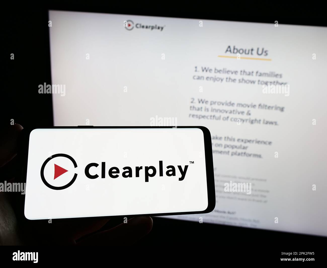 Personne portant un smartphone avec le logo de la société de contrôle parental ClearPlay Inc. À l'écran devant le site Web. Mise au point sur l'affichage du téléphone. Banque D'Images