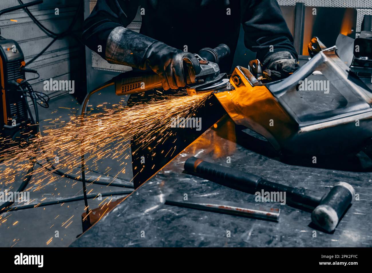 Mains de travailleurs meulant un morceau de métal, France Banque D'Images