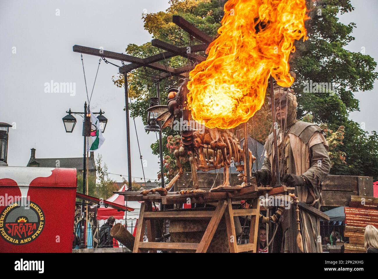 Flames est originaire de la bouche d'un dragon qui respire le feu lors du festival international de marionnettes de Skipton. L'opérateur est sur des pilotis, Banque D'Images