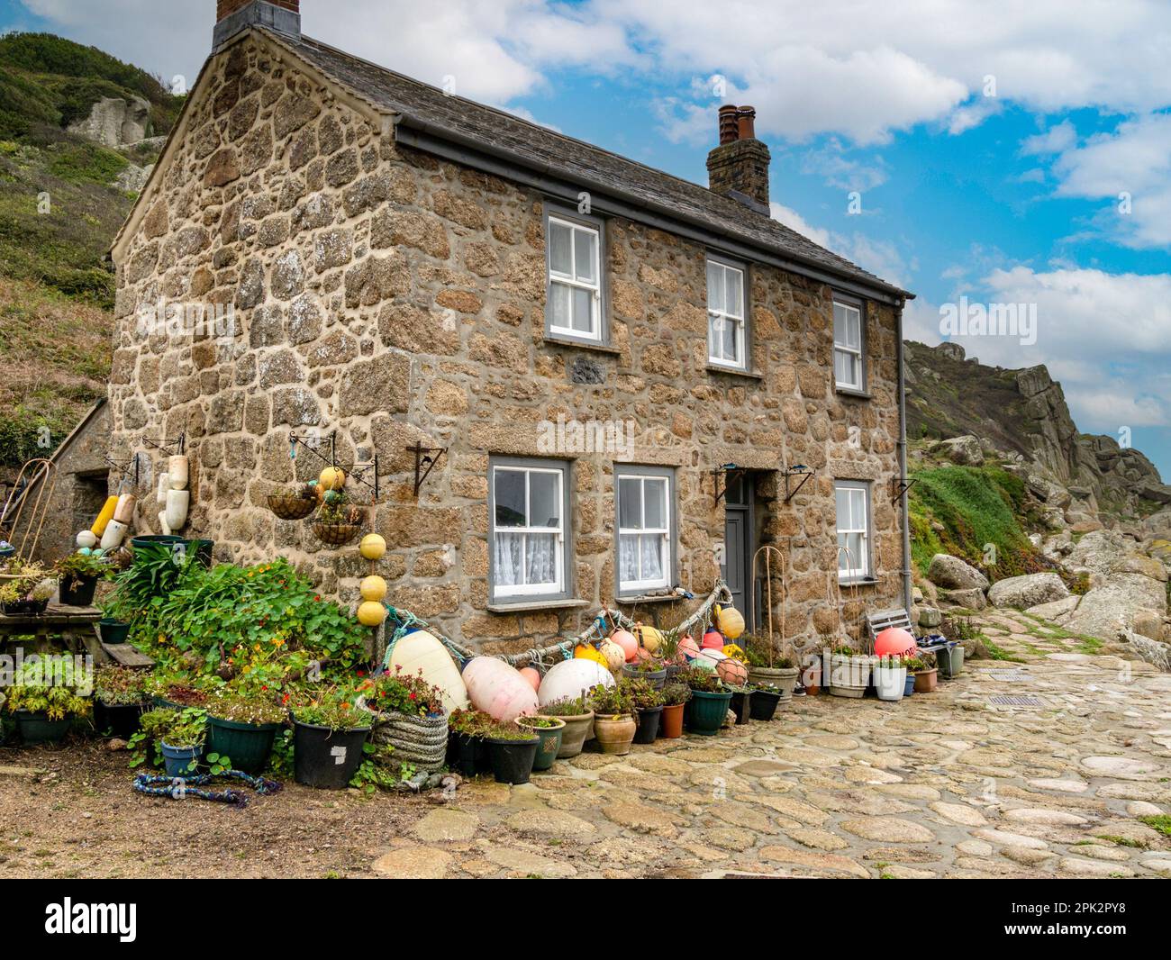 Beau vieux granit en pierre Cornouailles cottage bord de mer avec toit en ardoise et flotteurs de pêche et bouées à Penberth Cove, Cornwall, Royaume-Uni Banque D'Images