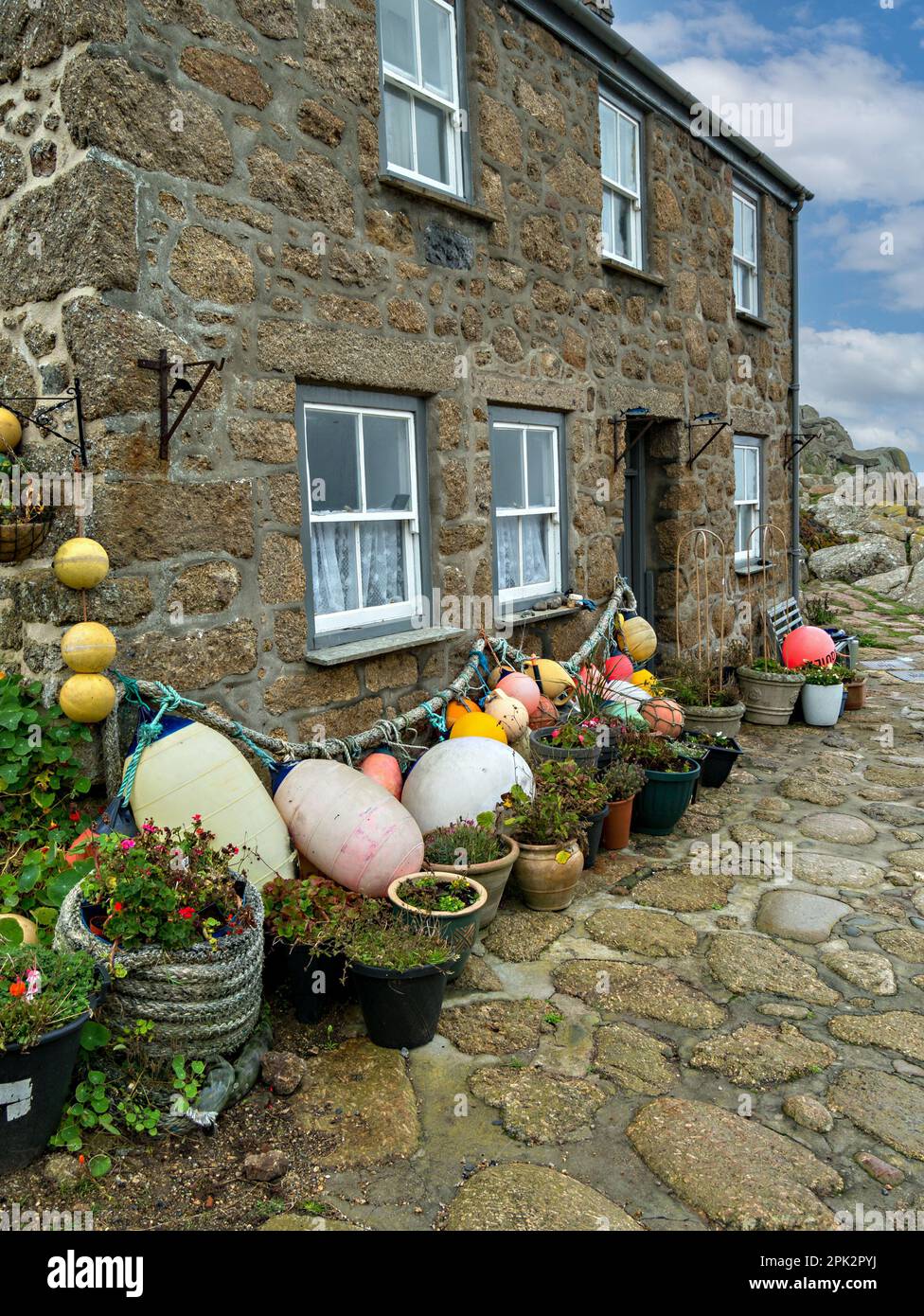 Beau vieux granit en pierre Cornouailles cottage bord de mer avec toit en ardoise et flotteurs de pêche et bouées à Penberth Cove, Cornwall, Royaume-Uni Banque D'Images