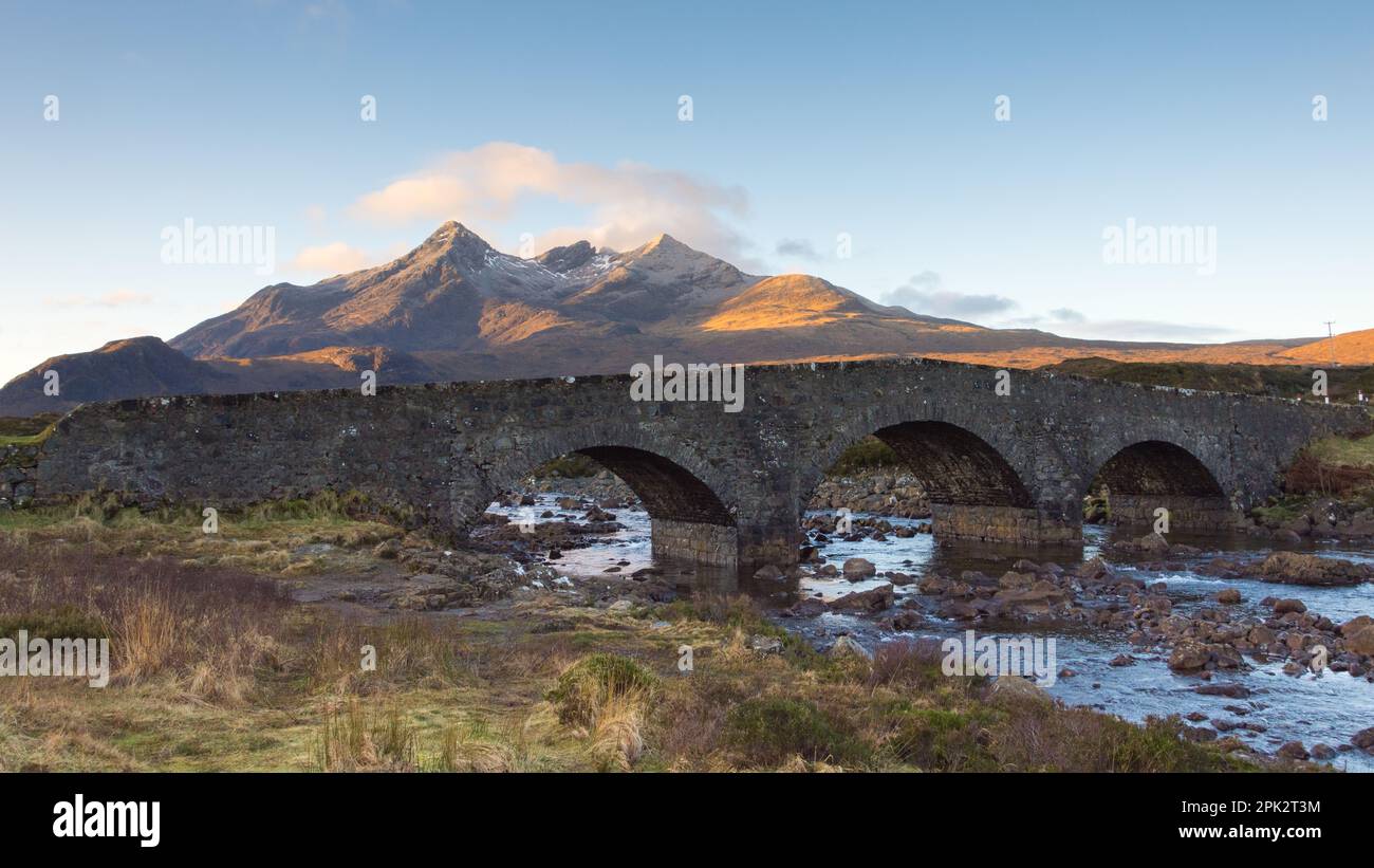 Sligachan Old Bridge Isle of Skye Scotland avec les Cullin Mountais s'appâtent sous le soleil du matin. Eau qui coule sous le pont et le nuage Banque D'Images