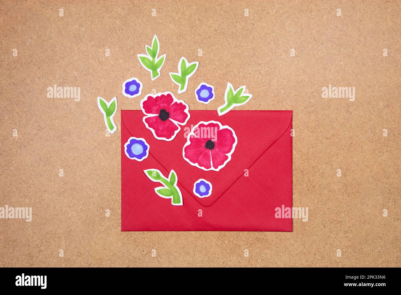 Enveloppe rouge avec fleurs dessinées à la main arrangement déco sur fond neutre. Concept de voeux, invitation, carte d'anniversaire de mariage. Banque D'Images