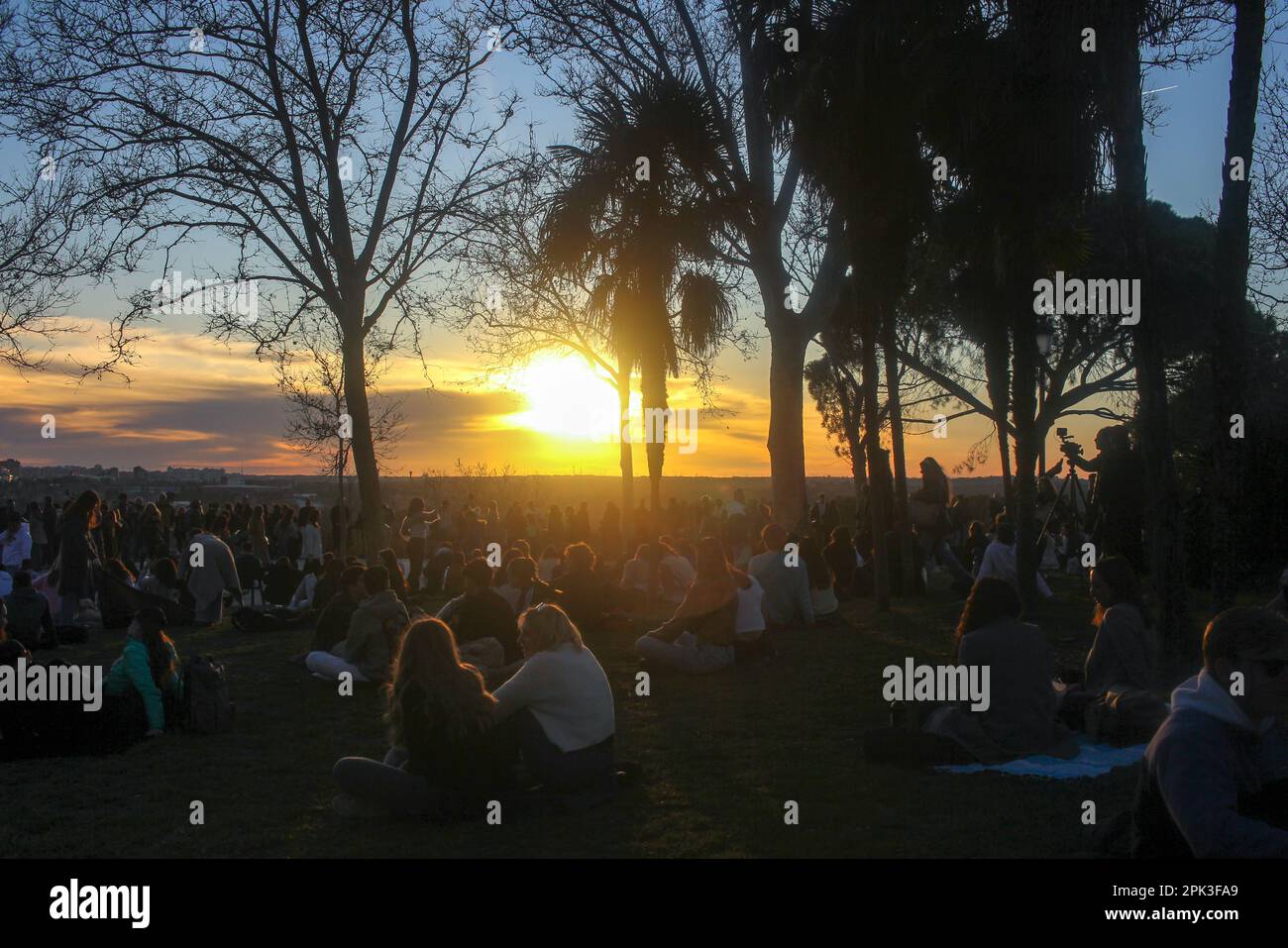 Les personnes dans un parc de Madrid appréciant les lumières de coucher de soleil se propageant le long de la ville Banque D'Images
