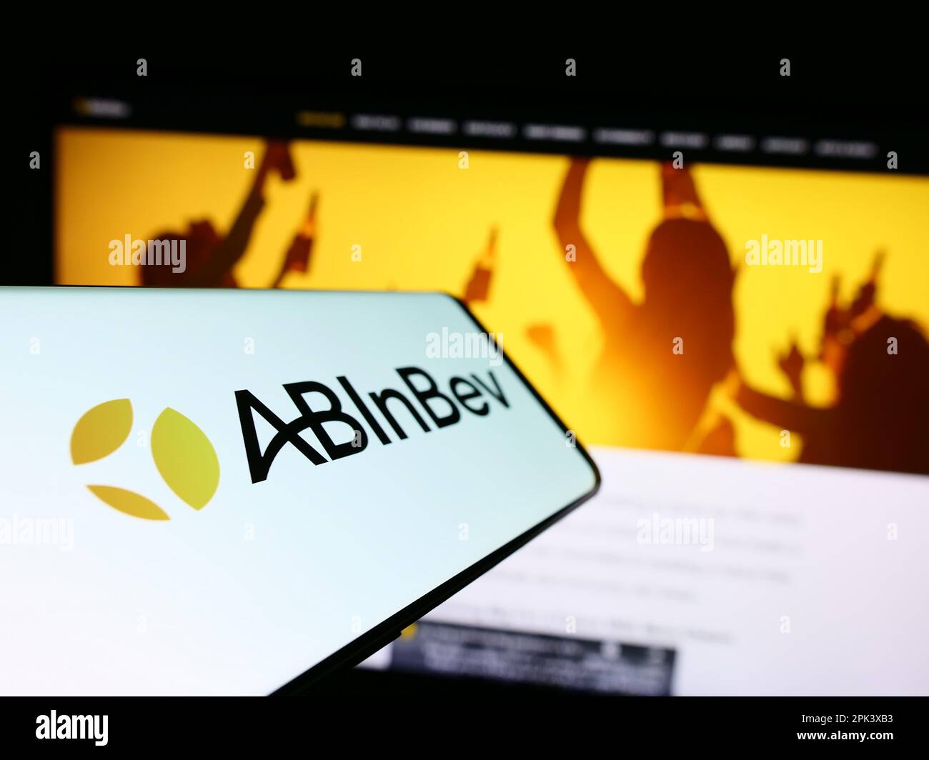 Téléphone portable avec logo de la société de brassage Anheuser-Busch InBev (AB InBev) sur écran devant le site. Mise au point au centre-gauche de l'écran du téléphone. Banque D'Images