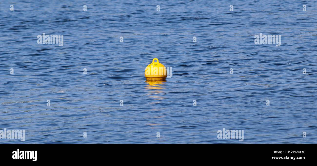 La boule de bouée flottante jaune sur la surface de l'eau marque la limite de la zone de baignade sécuritaire Banque D'Images