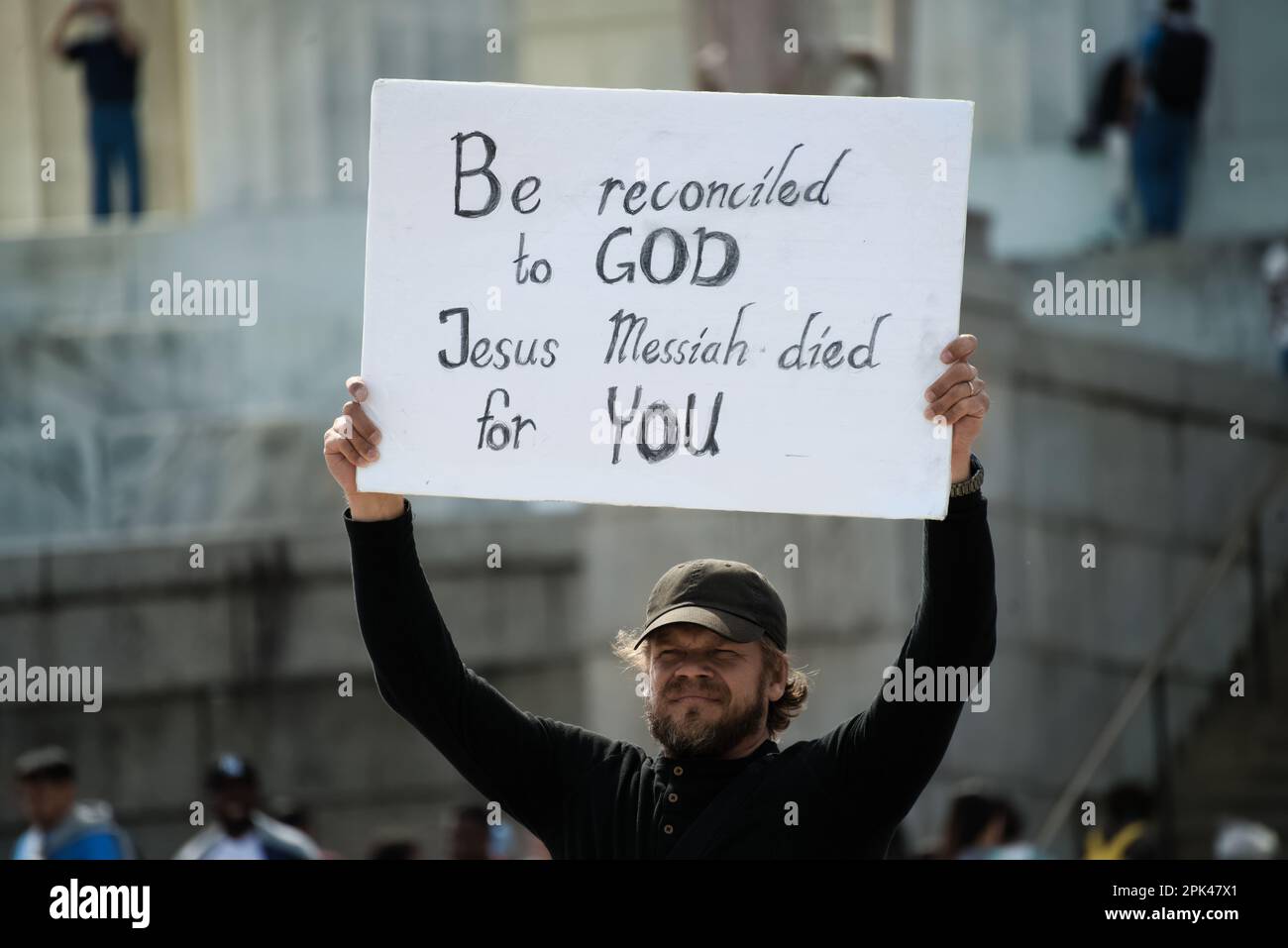 Washington, DC - 3 avril 2023: Un activiste chrétien masculin tient un signe de protestation soutenant Dieu et Jésus messie à l'extérieur du Mémorial de Lincoln. Banque D'Images